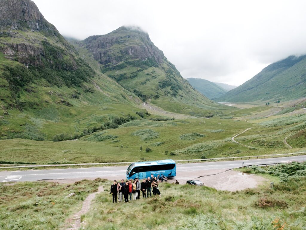 A group of tour passengers walking up Glen Coe